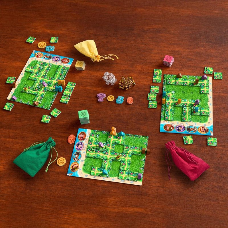 Karuba: losetas de sendero que se colocan simultáneamente, exploradores que avanzan hacia los templos y el abstracto de construcción de rutas donde todos tienen las mismas piezas pero no el mismo resultado