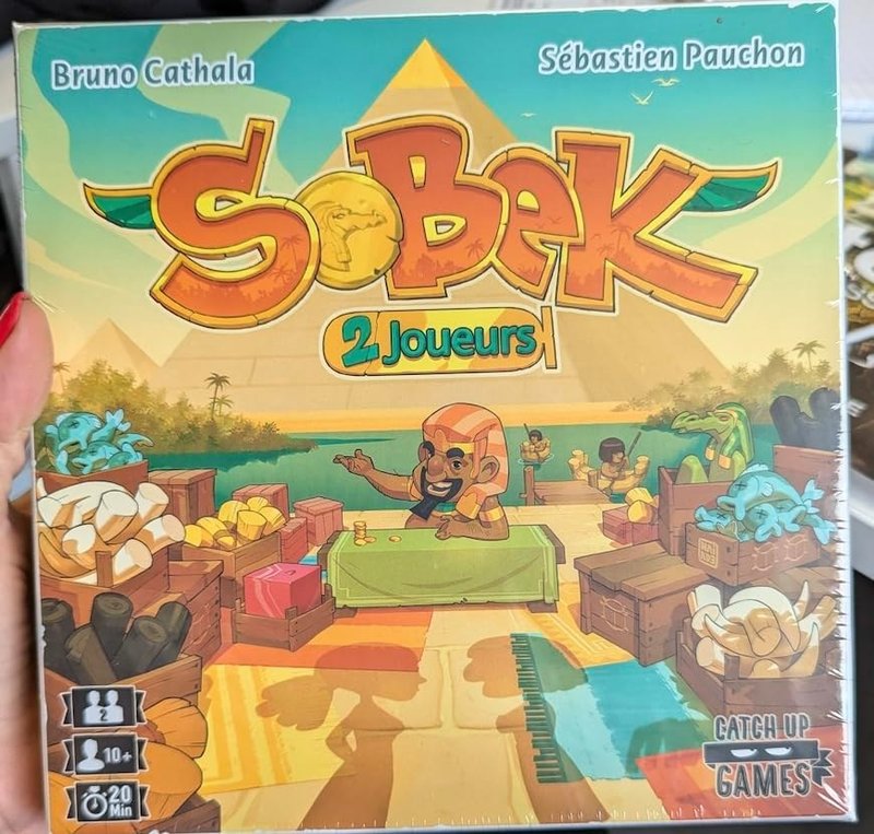 Sobek: 2 Faraones — dos tableros enfrentados, mercancías que se compran con corrupción y el juego de cartas para dos donde contaminar la mano del rival es tan valioso como limpiar la propia
